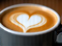 Arte latte de café de especialidad servido en taza de cerámica